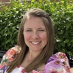 Professional woman smiling outdoors in natural greenery for corporate and business branding.