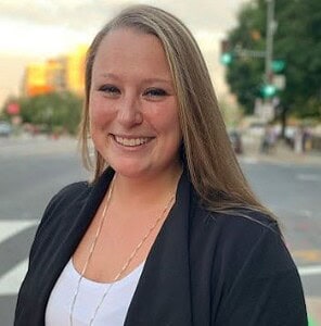 High-achieving woman smiling at outdoor business district for CTLG consulting services.