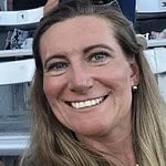 Professional woman smiling at a sports event, representing CTLG consulting expertise.