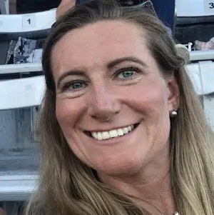 Professional woman smiling at a sports event, representing CTLG consulting expertise.