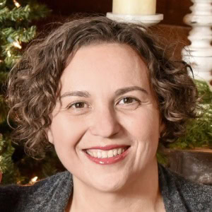 Professional woman smiling in festive setting, representing CTLG consulting services.