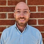 Professional business consultant smiling in front of brick wall, CTLG branding.