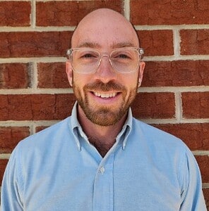 Professional business consultant smiling in front of brick wall, CTLG branding.