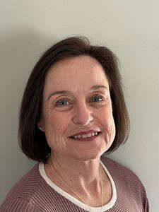 Confident woman smiling, professional corporate headshot for business and consulting services.