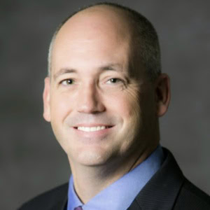 Professional business consultant smiling in formal attire, corporate image for CTLG Consulting.