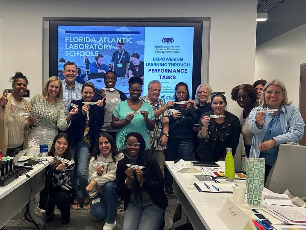 Bright group photo of educators and team members holding inspirational messages at CTLG conference.